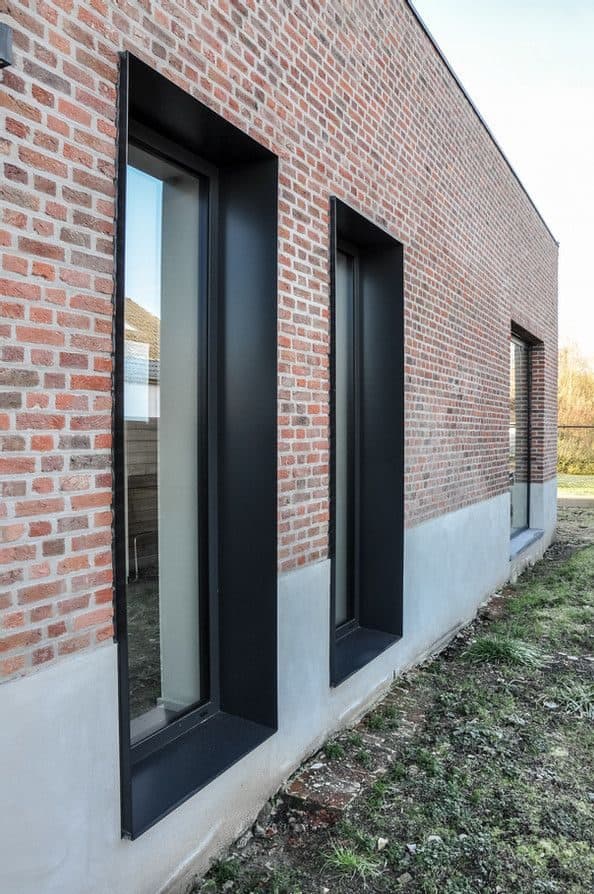 Cihlové pásky na fasádě s černými špaletami oken